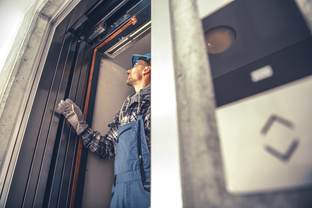 New Residential Building Elevator Installation. Final Checks Performed by Professional Elevator Systems Technician in His 40s.
