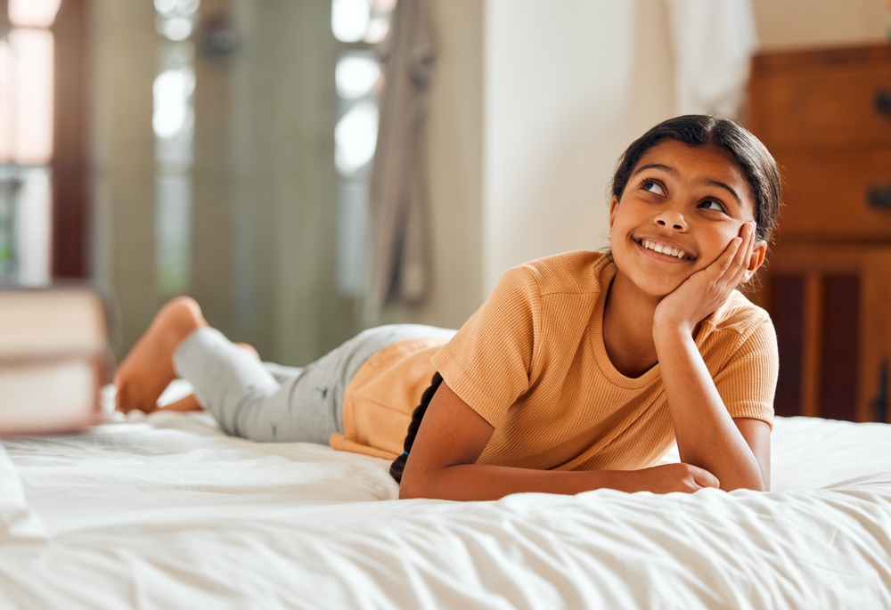 Fantasy, bed and black girl thinking, ideas and relax on weekend, happiness and summer break. African American female child, young lady or daydreaming, imagination and thought with wonder and bedroom