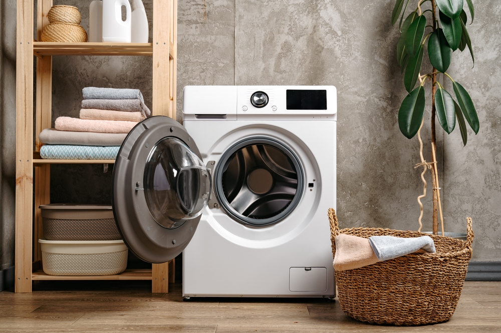 Laundry room interior with washing machine near gray grunge wall
