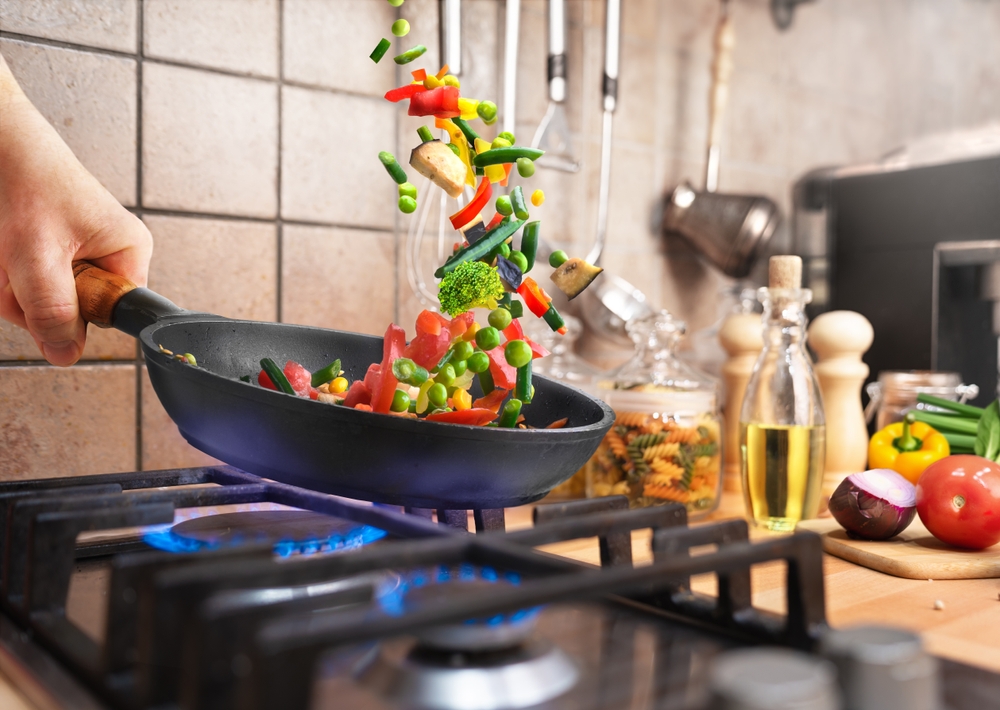 Preparing Various chopped vegetables in a frying pan over the gas stove for evening dinner at home kitchen