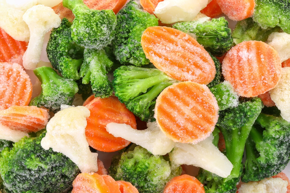 Mix of different frozen vegetables as background, top view
