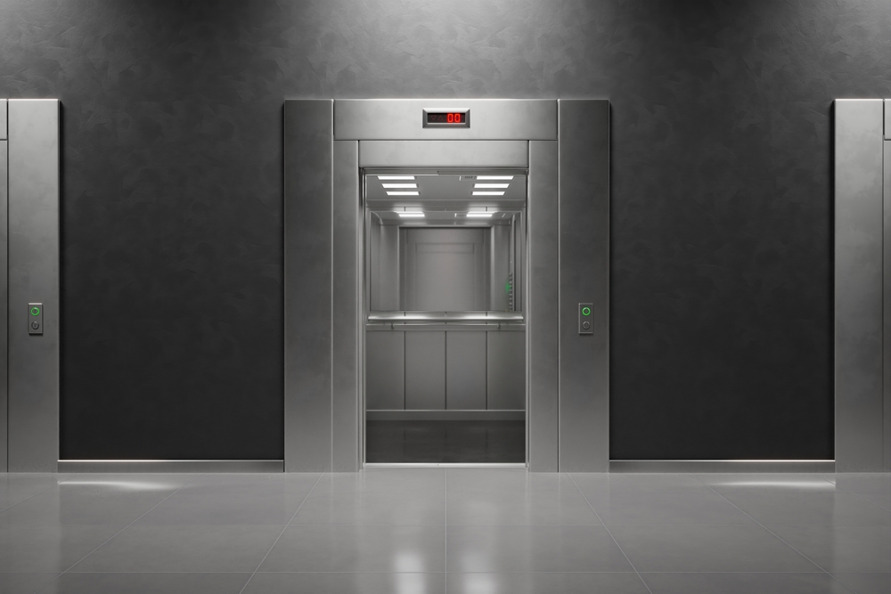 Frontal perspective of sophisticated, closed elevator doors within a modern, minimalist building interior, highlighted by subtle ambient lighting.