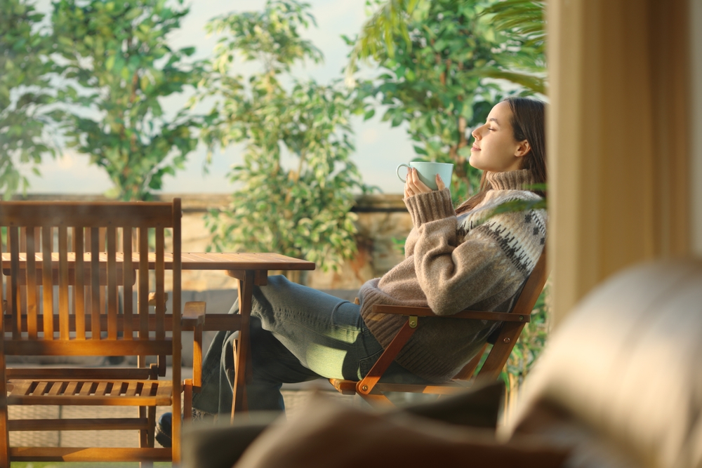 Profile of a woman in a house terrace drinking coffee and breathing