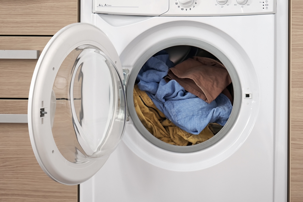 Close-up of a built-in washing machine in a home kitchen. Preparing to wash dirty clothes.
