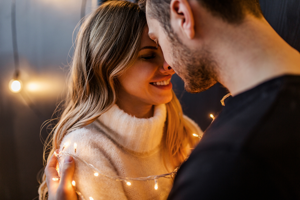 Young couple in love hug each other on the black background