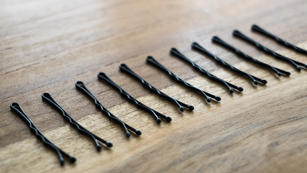 Bobby pins isolated on wooden background