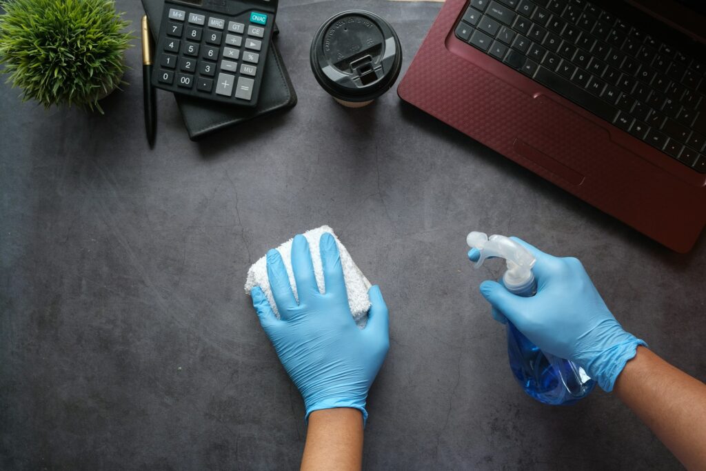 person in blue gloves sitting beside black laptop computer

