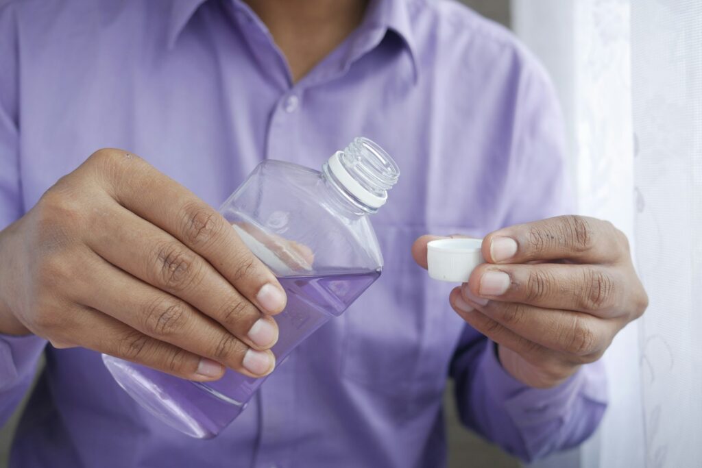 person holding white plastic bottle

