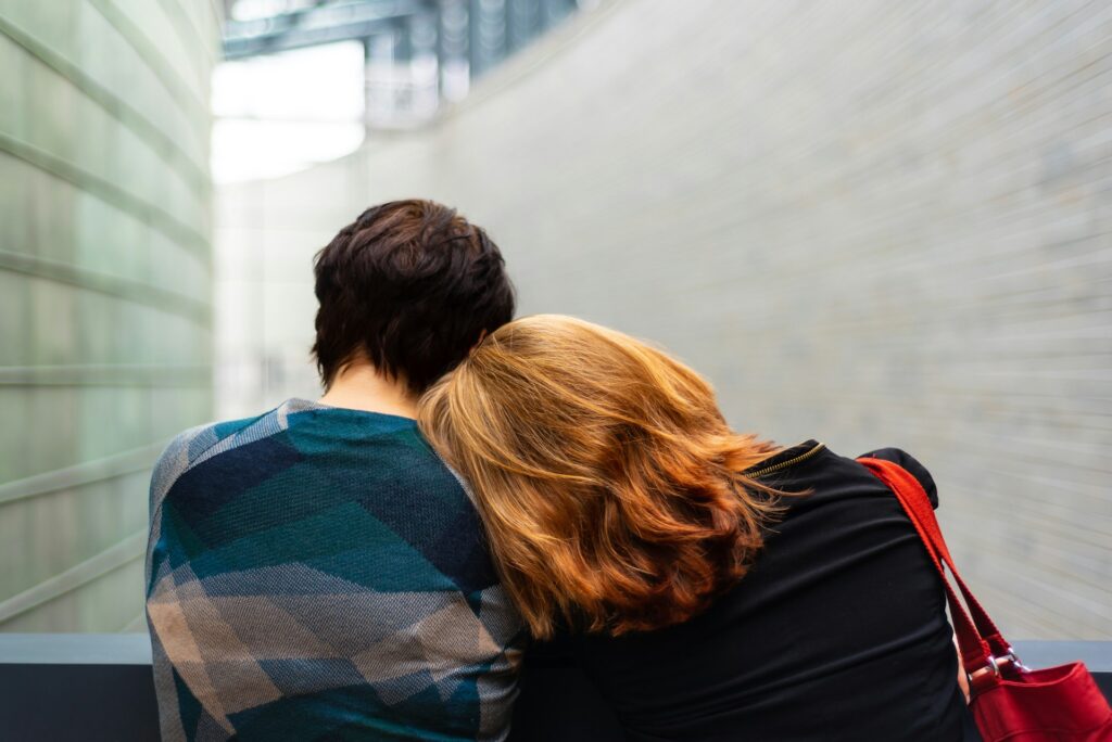 a woman rests her head on another person's shoulder
