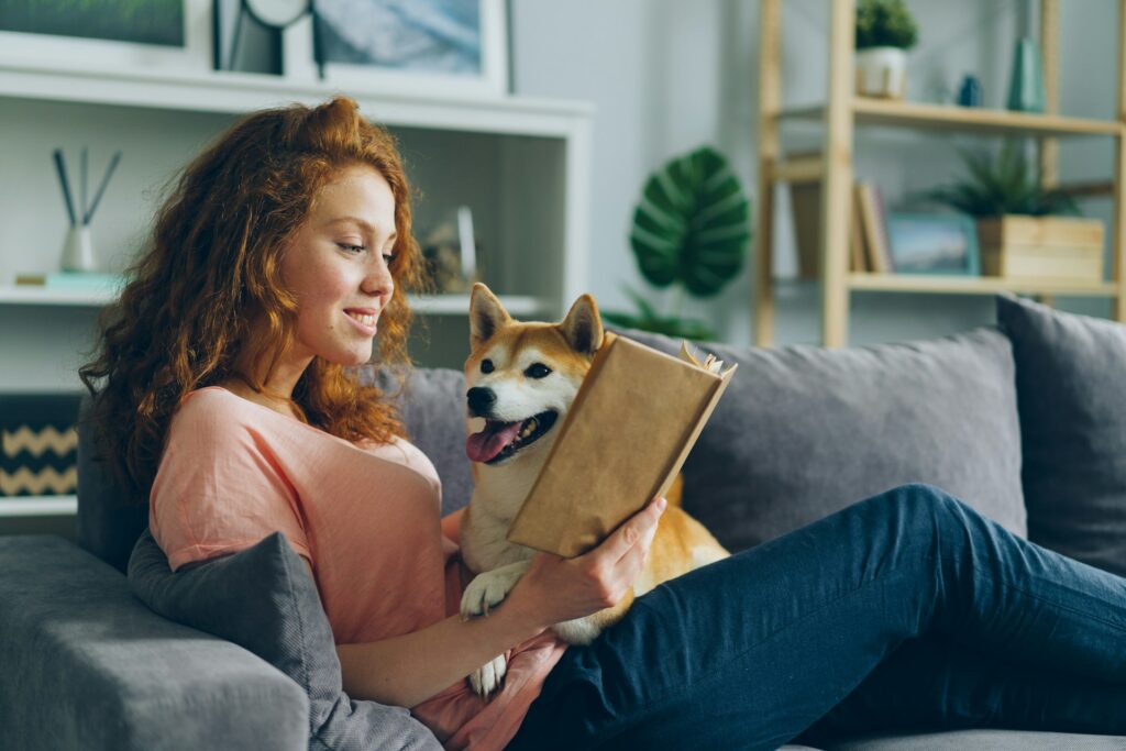 a woman sitting on a couch holding a dog
