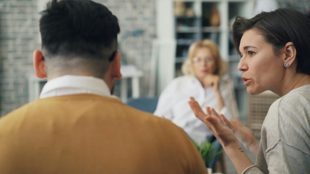 a woman talking to a man at a table

