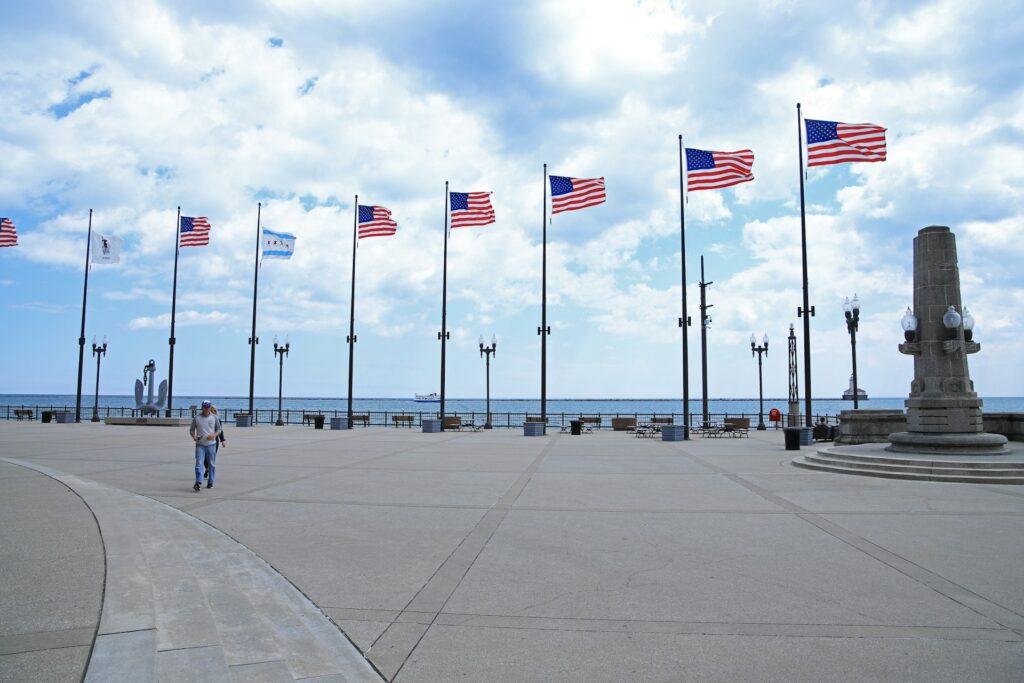 a man walking down a sidewalk next to a bunch of american flags
