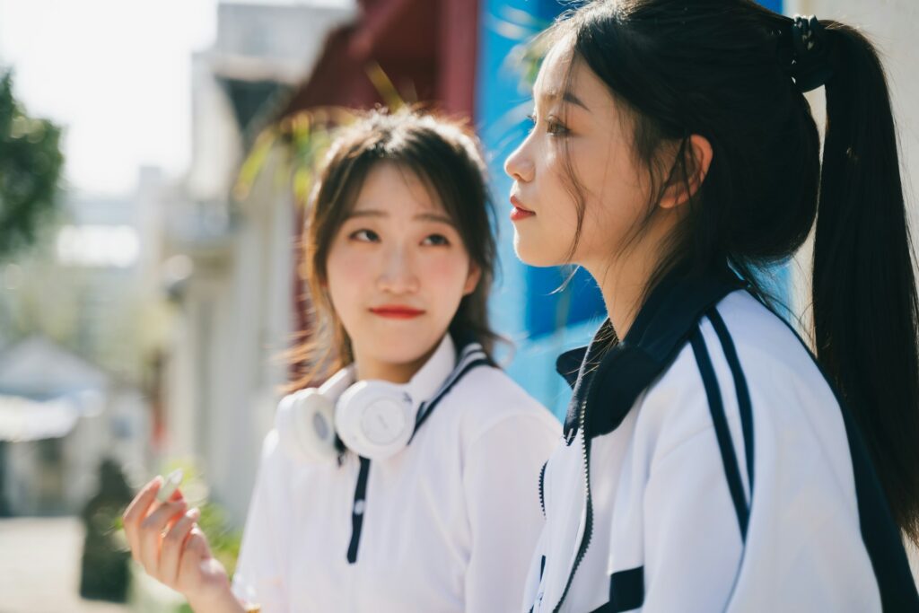 two young women standing next to each other
