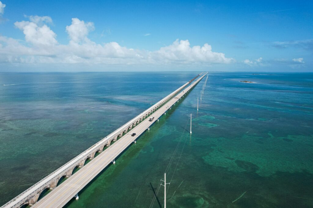 An aerial view of a bridge spanning the ocean
