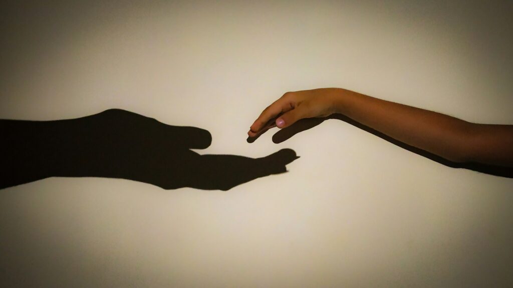 two hands reaching out towards each other
