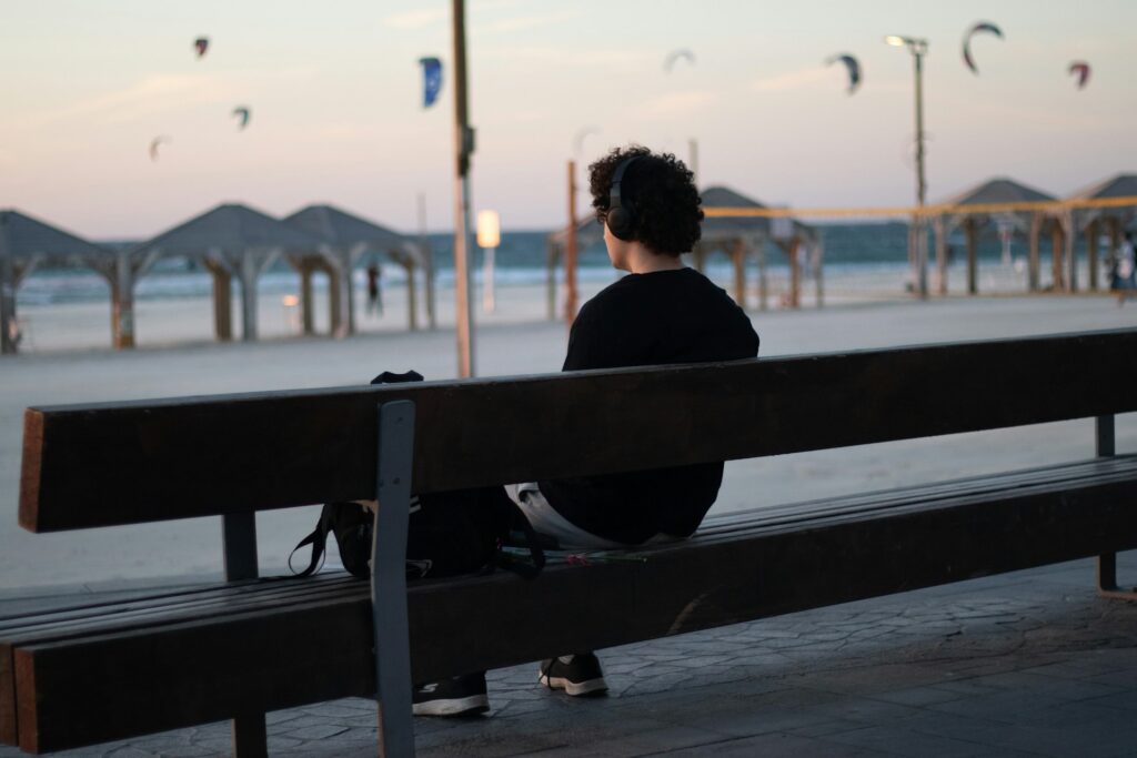 A person sitting on a bench in front of a body of water
