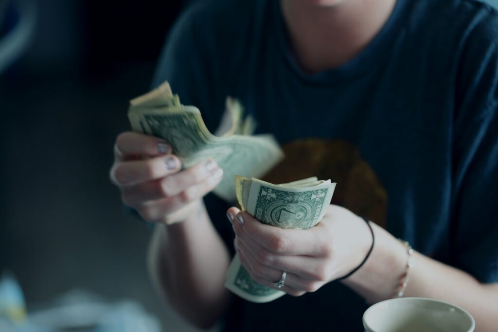 focus photography of person counting dollar banknotes
