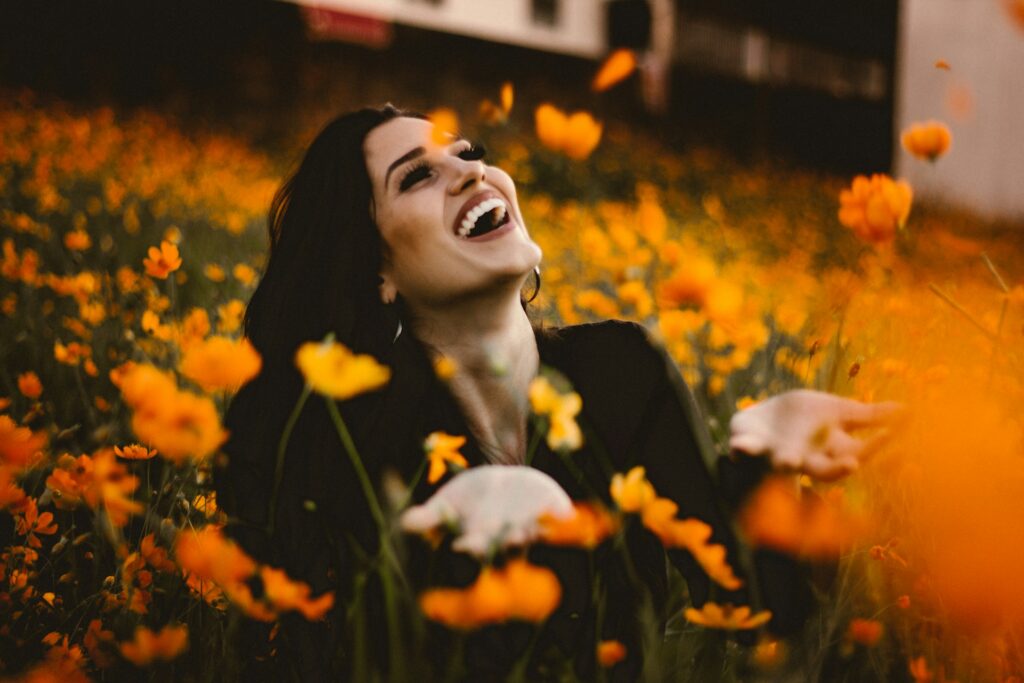 woman laughing on flower field
