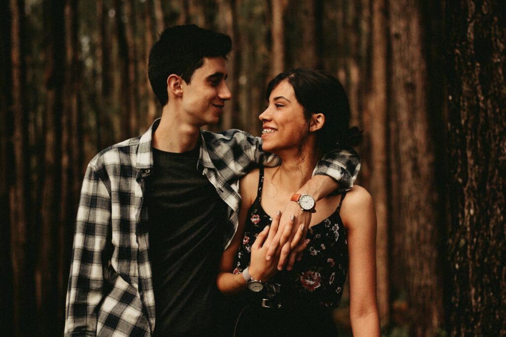 man wrapping arm on woman facing each other
