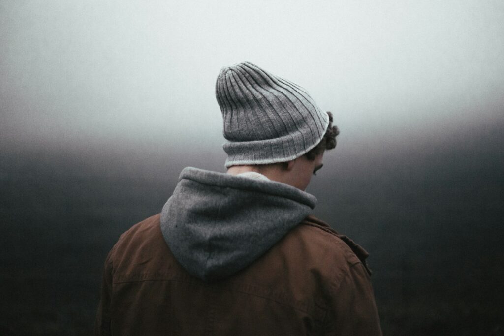 man wearing knit cap on grey background
