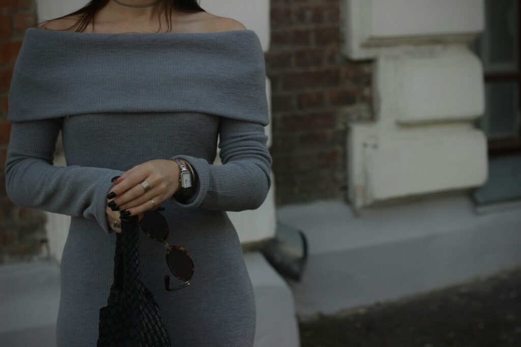 A woman in a grey dress is walking down the street
