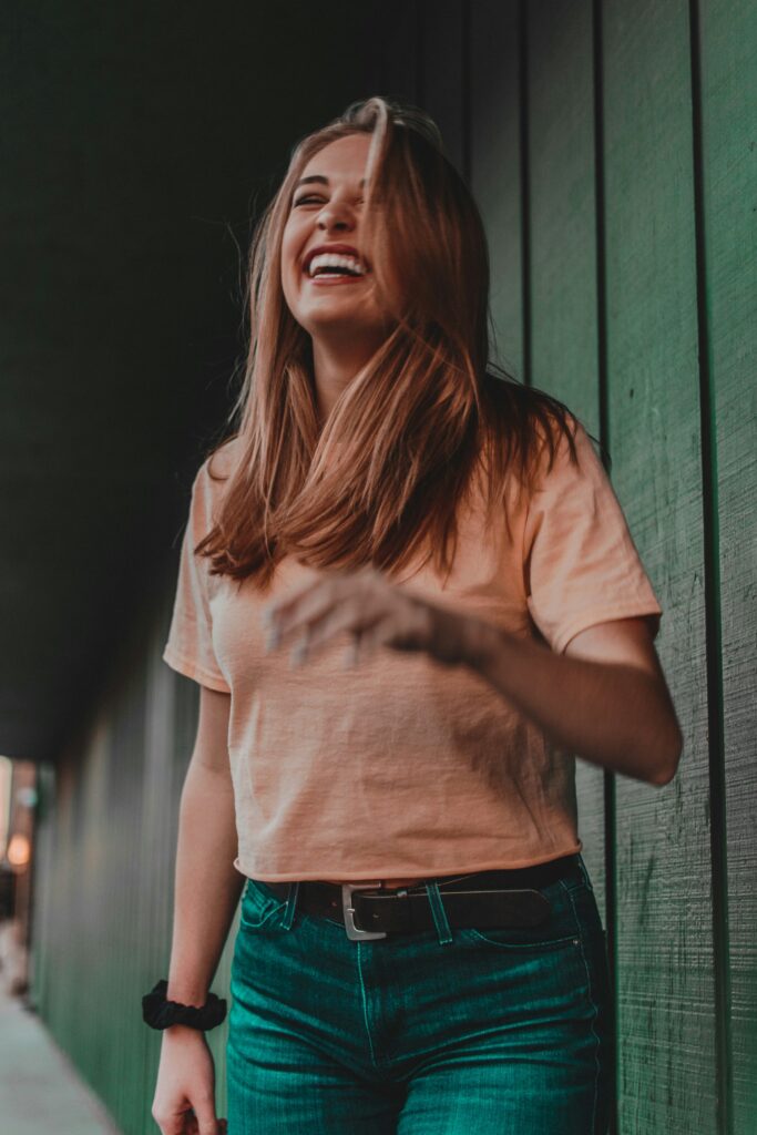 woman in orange shirt laughing

