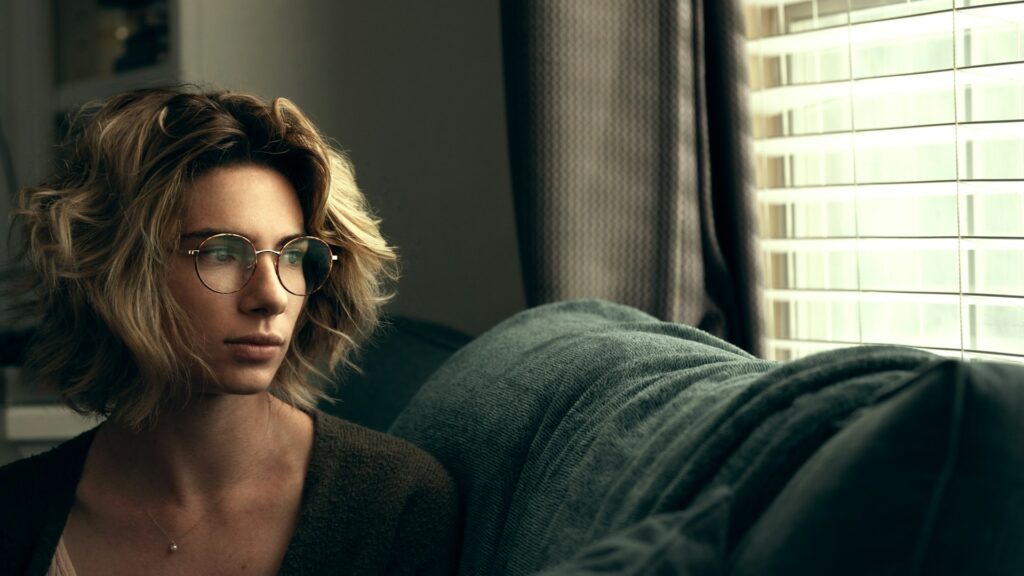 a woman wearing glasses sitting on a couch
