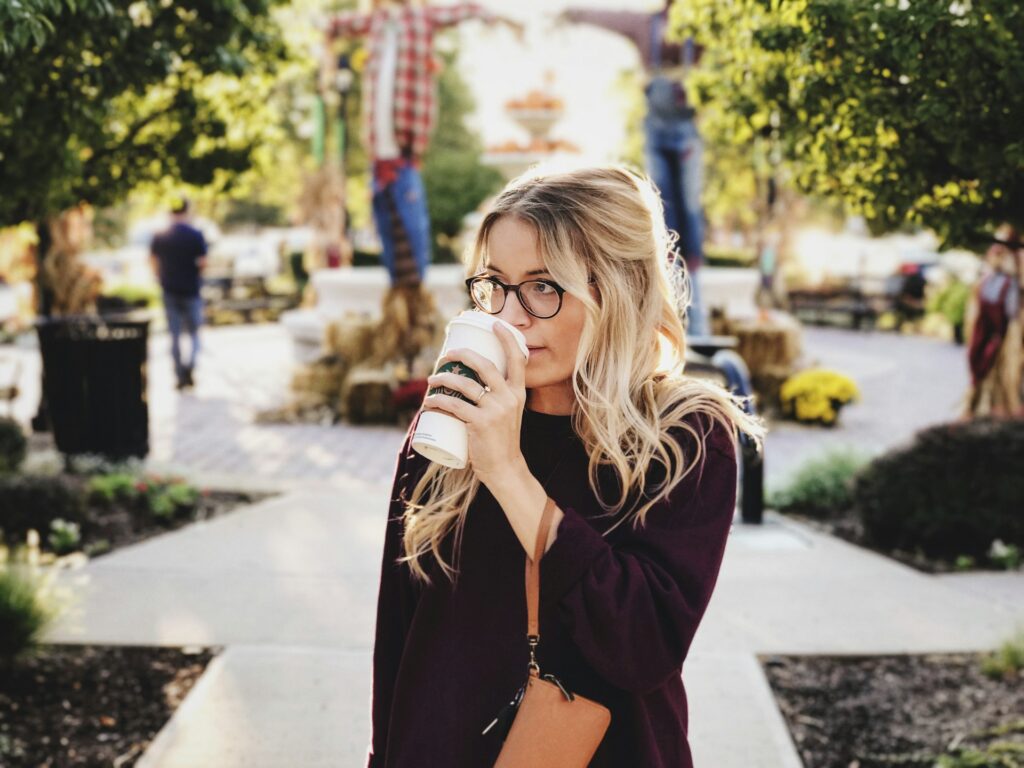 woman drinking on white cup
