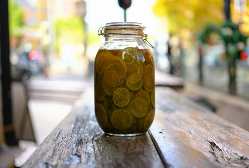 A jar of pickles sitting on top of a wooden table
