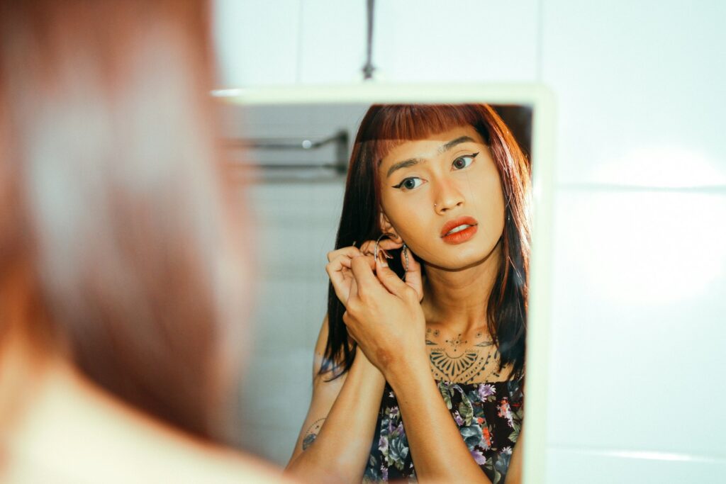 a woman looking at herself in the mirror
