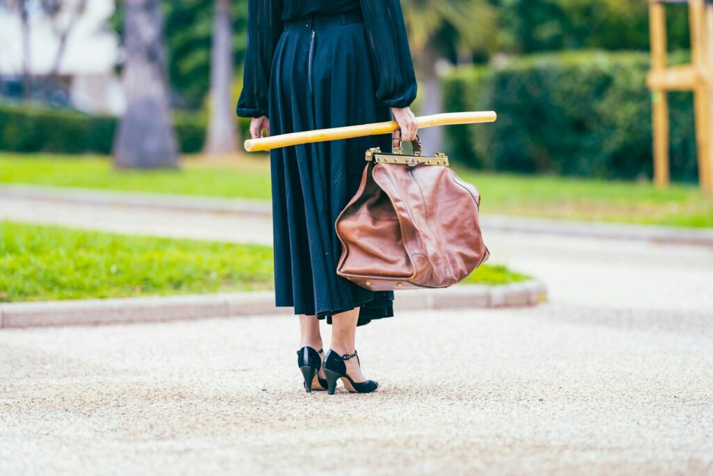 A woman walking down a street holding an umbrella
