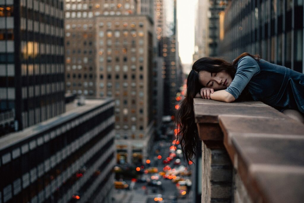 woman leaning on top building rail during daytime
