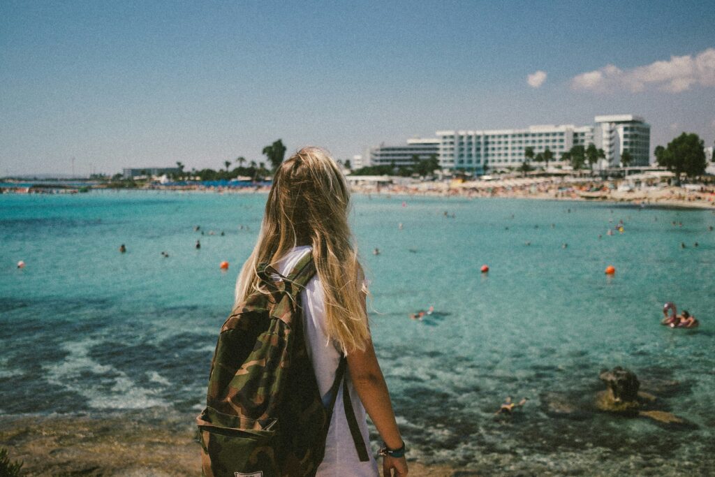 woman in brown jacket standing on beach during daytime
