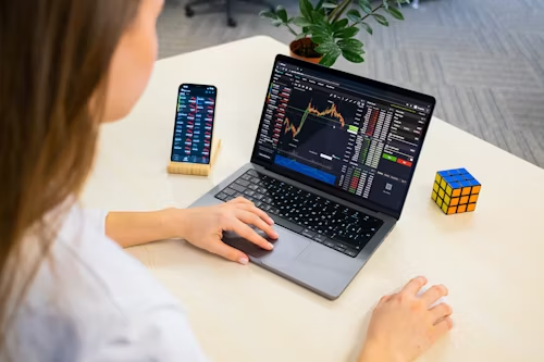 Woman infront of open laptop looking at investments. 