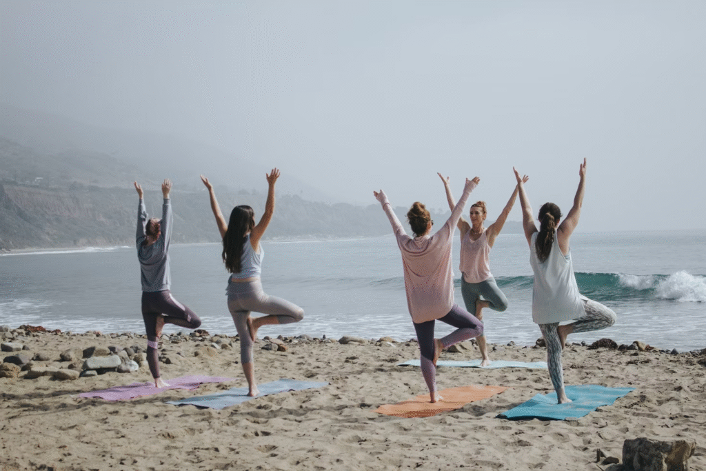 image of people practicing yoga on the beach