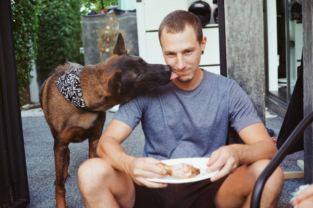 man being licked by a dog