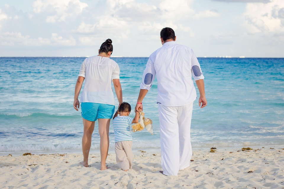 family walking on the beach with a toddler, image