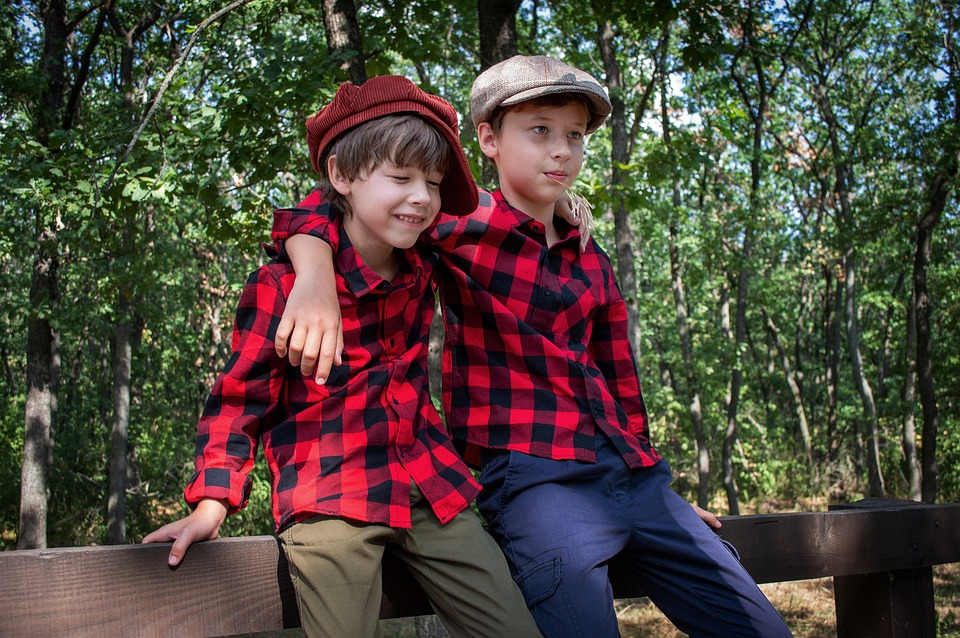 siblings on a bench in a park, image