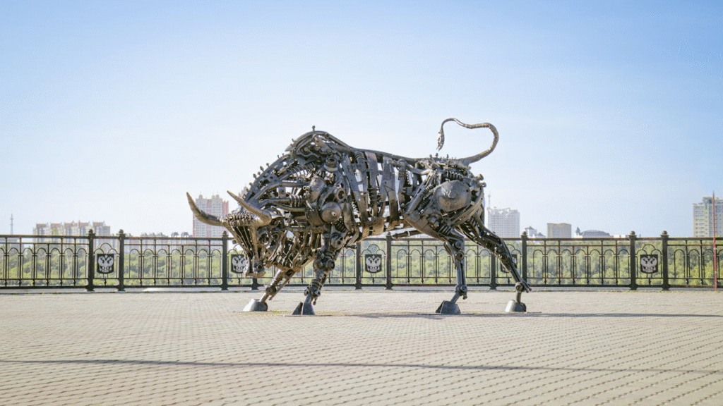 A large metal bull statue in the middle of a park
