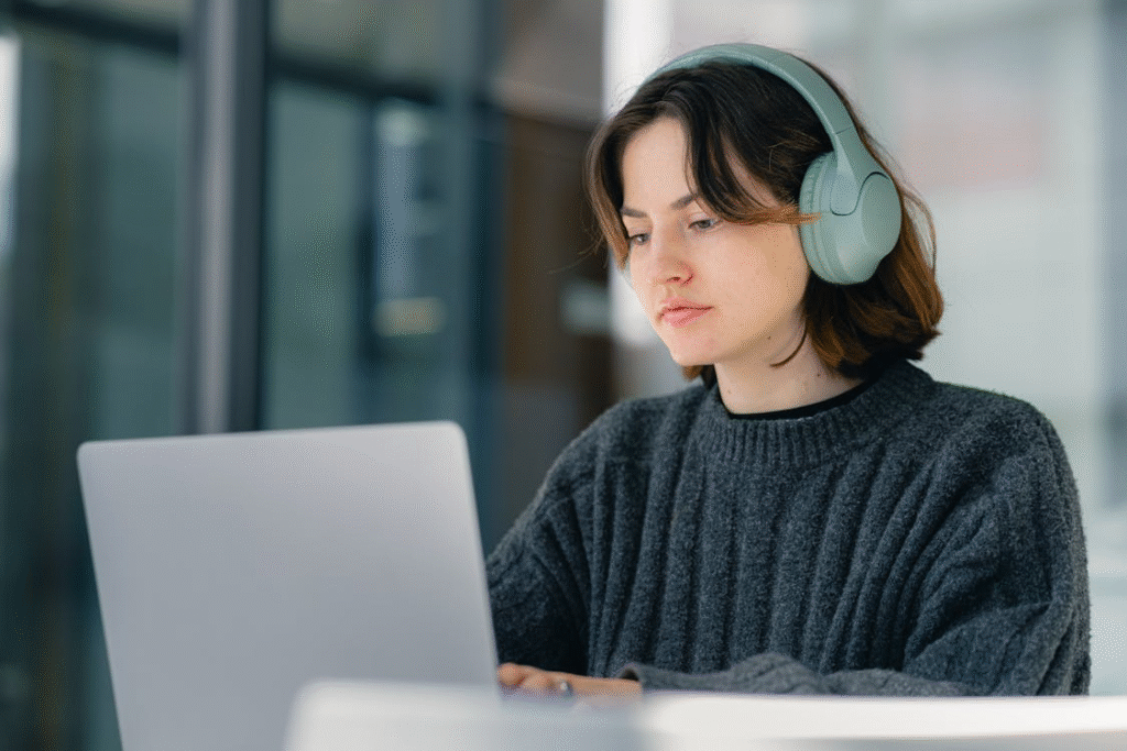 Focused Young Woman Working on Laptop with Headphones