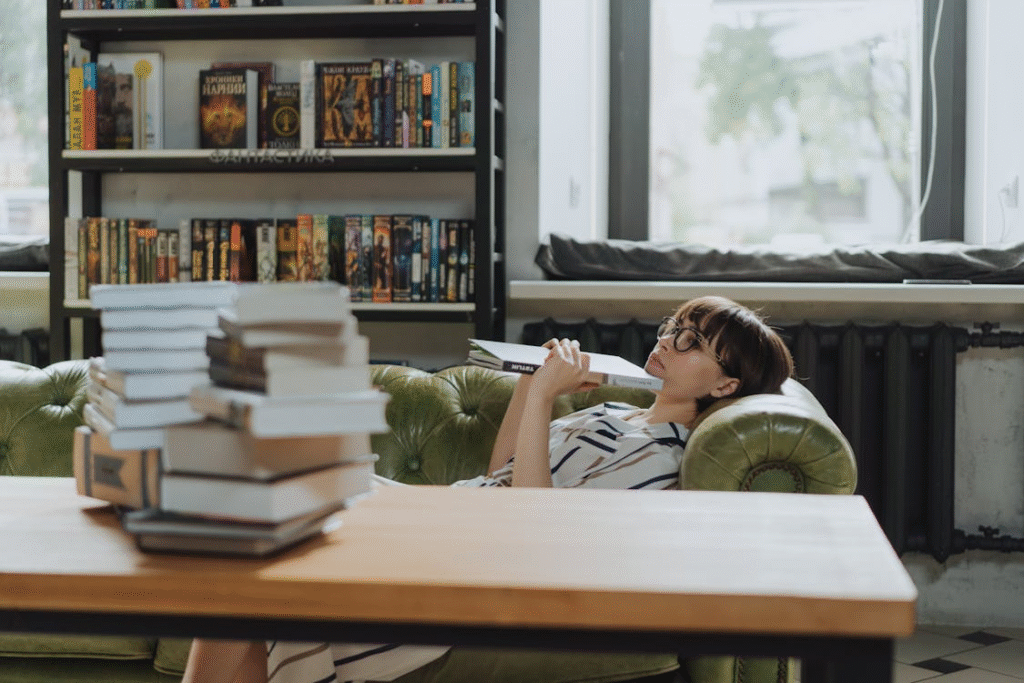 Person in Gray T-shirt Lying on Bed Reading Books