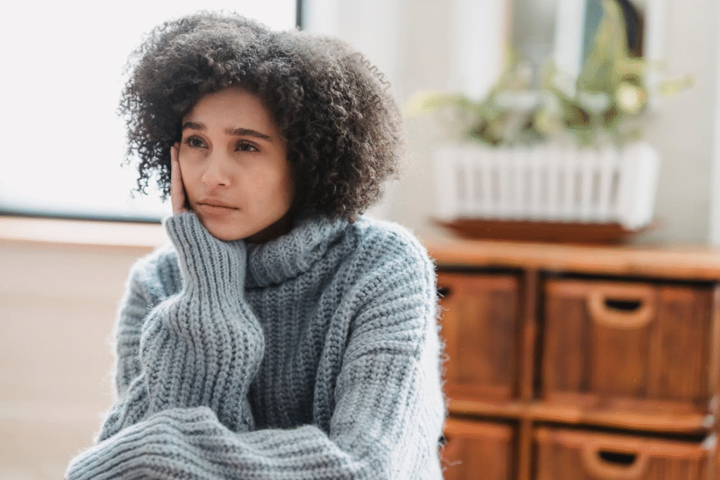 Depressed black woman sitting in room