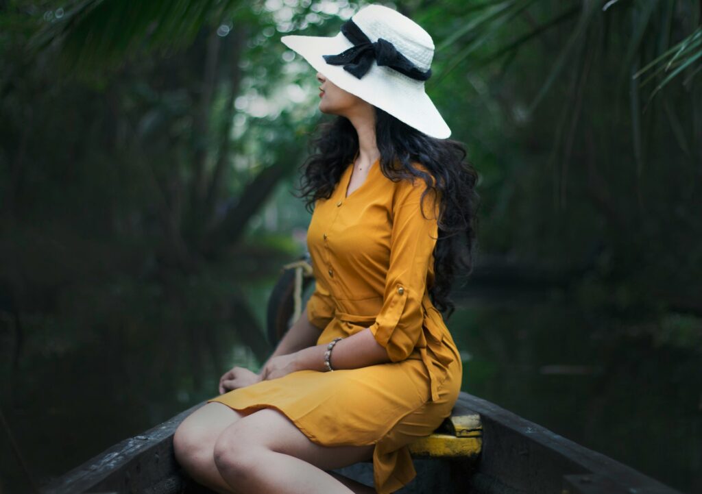 woman sitting on black surface near leaves
