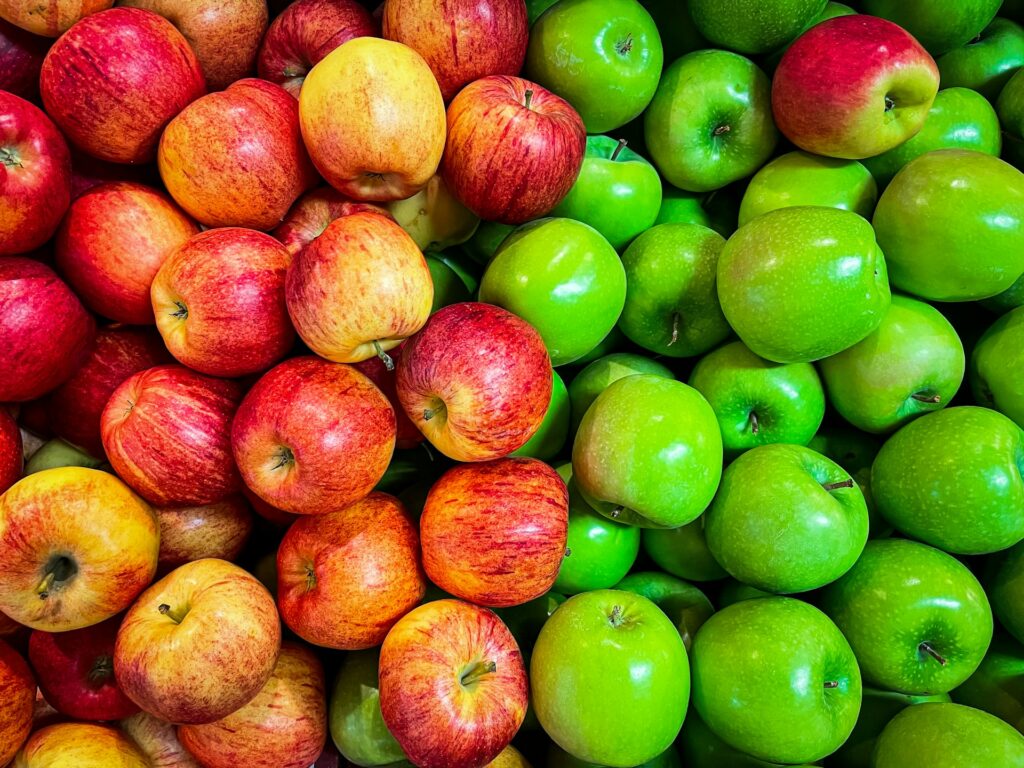 green and red apples on white plastic container
