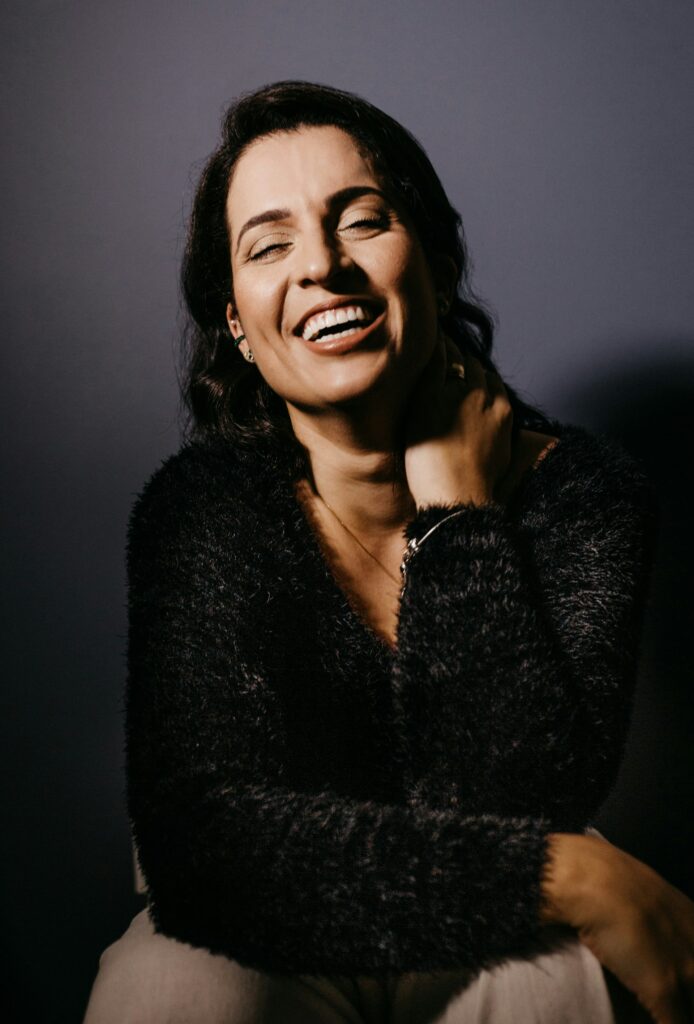 smiling woman in black fur coat
