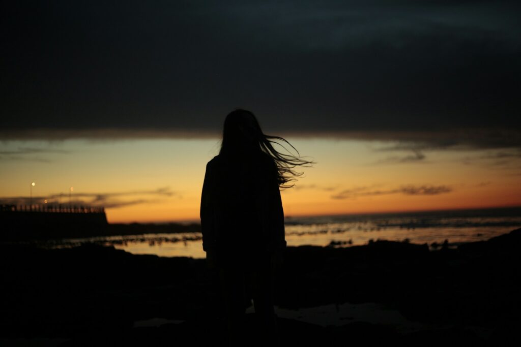 silhouette of woman near beach
