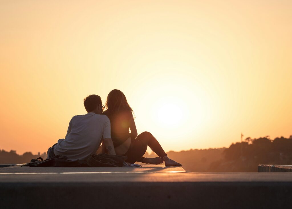 couple sitting near trees during golden hour
