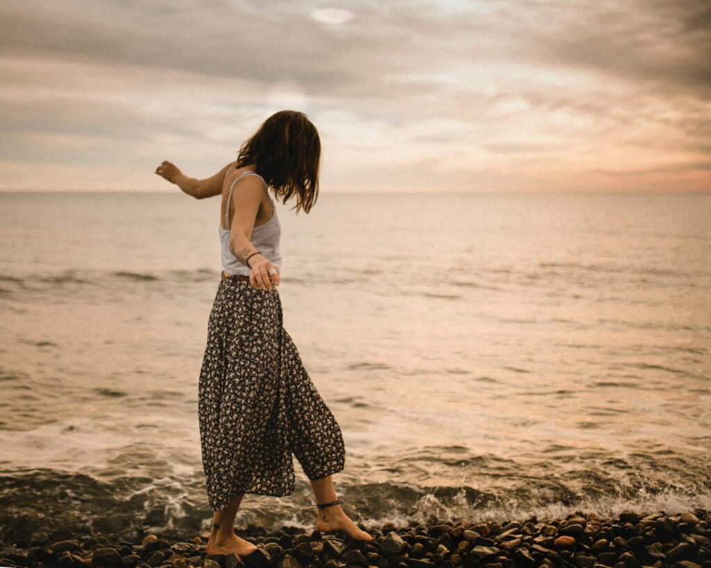 woman walking on rocks in beach
