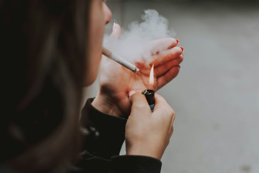 woman lights her cigarette with lighter
