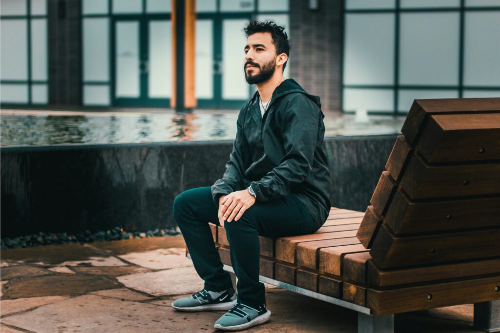 man sitting on wooden lounge
